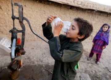 Seorang bocah Pakistan meminum air dari pompa umum di pinggir kota Islamabad. Pakistan menghadapi krisis parah akibat kombinasi pembengkakan populasi dan kegagalan pertanian yang membuat pasokan bersih berkurang.