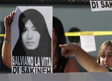 Seorang demonstran mengusung poster Sakineh Mohammadi Ashtiani pada sebuah unjuk rasa di depan Kedutaan Besar Iran di Roma, Italia.