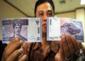 Seorang pegawai Bank Indonesia memperlihatkan contoh uang baru keluaran 2010 pecahan Rp10.000 di Kantor BI Makassar, Selasa (20/7). BI mengeluarkan uang baru keluaran 2010 pecahan Rp1000 (koin) dan Rp10.000 (kertas).