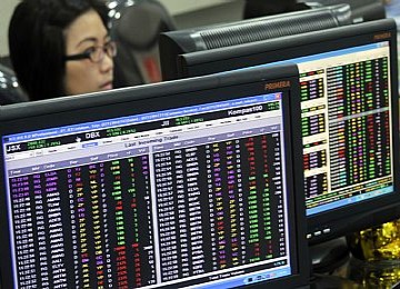 Seorang pialang memantau pergerakan harga saham