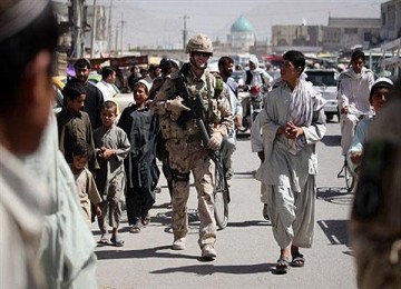 Seorang tentara NATO melakukan patroli di kota Kandahar.