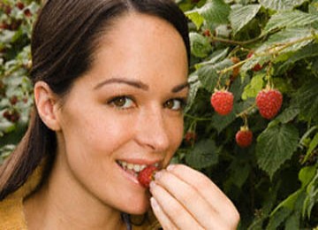 Seorang wanita sedang makan buah.