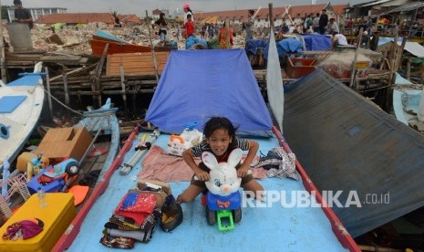 Seororang anak korban bongkaran pemukiman warga kawasan Pasar Ikan yang masih bertahan di atas perahu, Penjaringan, Jakarta Utara, Jumat (15/4). (Republika/ Raisan Al Farisi)