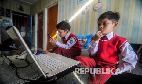 Sepasang anak kembar murid SD Bakti Nusantara mengerjakan Ujian Akhir Semester (UAS) Genap secara daring di kediamannya di Cinunuk, Kabupaten Bandung, Jawa Barat, Senin (8/6/2020). Kementerian Pendidikan dan Kebudayan mewajibkan kegiatan belajar mengajar serta ujian dilakukan secara daring oleh peserta didik hingga pandemi COVID-19 terkendali.