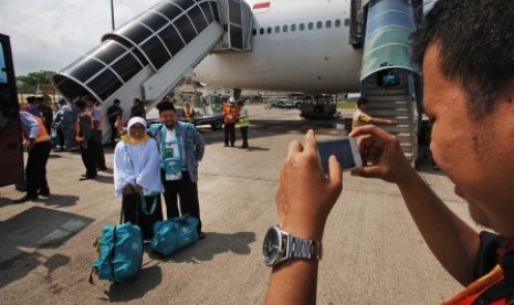 Sepasang calon haji berfoto sebelum pemberangkatan kloter pertama embarkasi Padang, di Bandara Internasional Minangkabau (BIM), Padangpariaman, Sumatera Barat, Jumat (21/8).