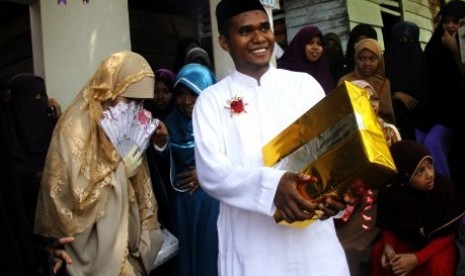 Sepasang pengantin nikah massal keluar dari ruangan nikah dan disambut para keluarga saat mengikuti nikah massal di Pesantren Hidayatullah, Makassar, Sulawesi Selatan, Ahad (1/11).