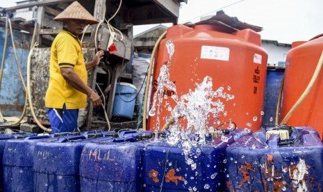 Serang pekerja mengisi air bersih ke dalam jerigen untuk dijual di Muara Angke, Jakarta, Senin (28/1/2019).