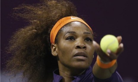 Serena Williams, petenis Amerika Serikat, melepaskan servis saat menghadapi petenis Polandia, Urszula Radwanska, di laga turnamen Qatar Terbuka di Doha pada Kamis (14/2). 