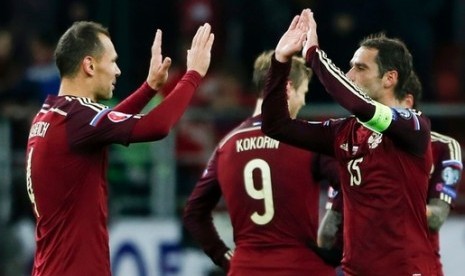 Sergei Ignashevich (kiri) dan Roman Shirokov merayakan kemenangan atas Montenegro yang membawa Rusia lolos ke putaran final Piala Eropa 2016 sebagai wakil Grup G.