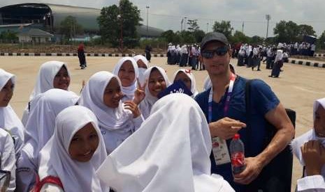 Sergent Richard David (kanan) saat melayani permintaan foto para pelajar di venue dayung, Jakabaring Sport City, Palembang, Senin (20/8).