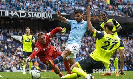 Sergio Aguero menendang bola ke arah gawang Huddersfield pada laga Liga Primer Inggris di Emirates Stadium, London, Ahad (19/8).