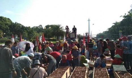 Serikat Tani Teluk Jambe gelar Aksi Kubur Diri dalam rangkat memperingati Hari Buruh di Monas, Jakarta Pusat, Senin (1/5). 