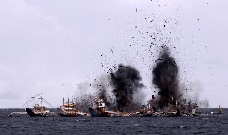 Serpihan kapal berhamburan ke udara saat penenggelaman kapal penangkap ikan ilegal di perairan Bitung, Sulawesi Utara, Senin (22/2)