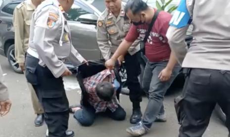  Pernyataan Wapres soal Penembakan di Kantor MUI, Singgung Motif Aksi Terorisme?. Foto:  Seseorang berbaju kotak-kotak yang ditengarai pelaku juga berhasil dibekuk saat terjadi penembakan di kantor Majelis Ulama Indonesia.