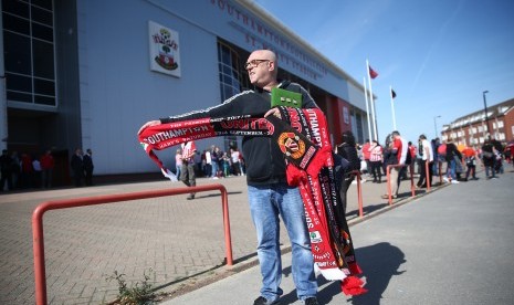 Seseorang menjual syal jelang laga Southampton lawan Manchester United di depan Stadion Saint Mary's, Sabtu (23/9). 