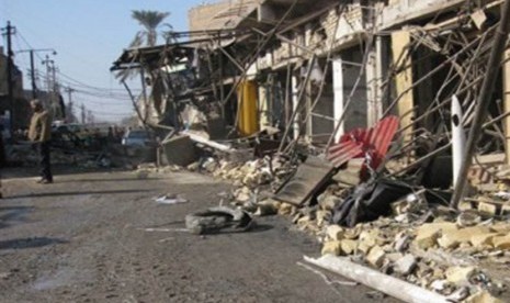 Seseorang pria tengah berdiri di sekitar lokasi ledakan bom di Baghdad.