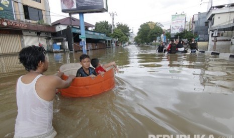 Seseorang warga mendorong drum berisi anak-anaknya yang bermain banjir di kawasan Jalan dr Soetomo di Samarinda, Kalimantan Timur (ilustrasi)