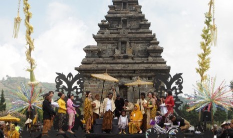 Sesepuh adat memotong rambut gembel seorang anak saat dilangsungkan ritual potong rambut gembel rangkaian dari kegiatan Dieng Culture Festival VIII di Komplek Candi Arjuna, Kawasan Dataran Tinggi Dieng, Batur, Banjarnegara, Jawa Tengah, Ahad (6/8). 