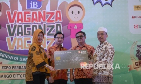 SEVP Risiko dan Komunikasi BNI Syariah Tribuana Tunggadewi (kiri), menyerahkan mock up kerjasama pengelolaan keuangan dana sekolah atau virtual account kepada Zamzam Syifa Boarding School KH Abdullah (kanan) disaksikan Direktur Penelitian, Pengembangan, Pengaturan dan Perizinan Perbankan Syariah OJK Deden Firman Hendarsyah (kedua kiri), dan Asisten Ekonomi dan Pembangunan Sekretariat Daerah Kota Depok Herman Hidayat dalam acara IB Vaganza Depok, Jabar, Jumat (6/10). 