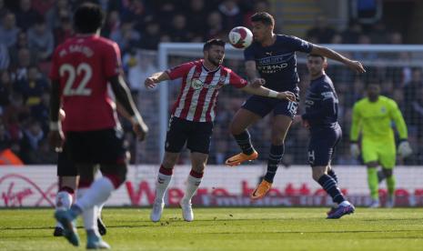  Shane Long dari Southampton, kedua dari kiri, dan Rodrigo dari Manchester City berebut bola dalam pertandingan sepak bola Piala FA Inggris antara Southampton dan Manchester City di stadion St Mary di Southampton, Inggris, Senin (20/3/2022). (AP Photo/Ala