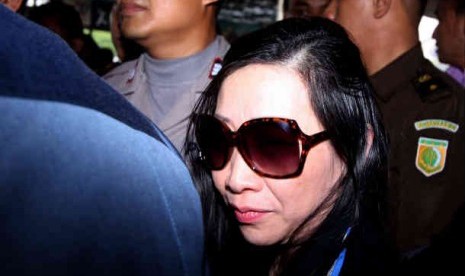  Sherny Kojongian dikawal petugas kepolisian saat tiba di Bandara Seokarno Hatta, Tangerang, Banten, Rabu (13/6). 