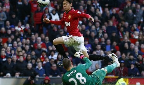 Shinji Kagawa (kiri), pemain Manchester United, mencetak gol usai memperdayai kiper Norwich City, Mark Bunn, dalam laga Liga Primer Inggris di Old Trafford, Manchester, Sabtu (2/3). 