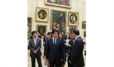 Shinzo Abe mendengarkan penjelasan dari Presiden Museum Louvre, Paris, Ahad (4/5).