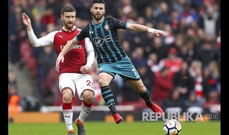 Shkodran Mustafi (kiri) ditempel ketat Shane Long (kanan) di Stadion Emirates, London, Ahad (8/4).