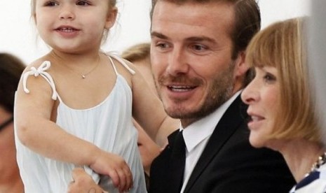 Si kecil Harper Beckham bersama ayahnya, David Beckham, dan Anna Wintour saat menghadiri pergelaran busana karya Victoria Beckham, beberapa waktu lalu.