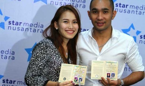 Penyanyi dangdut Ayu Rosmalina alias Ayu Ting Ting bersama suaminya Henry Baskoro Hendarso atau Enji memperlihatkan buku nikah usai mengelar jumpa pers di Jakarta, Jumat, (5/7). 