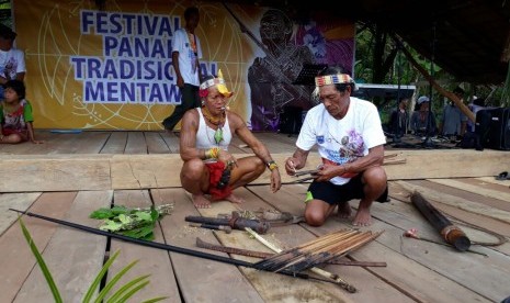 Sikerei atau dukun yang dihormati dalam tradisi Suku Mentawai menunjukkan cara pembuatan racun untuk berburu hewan.