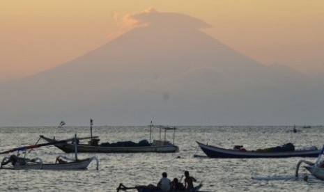 Siluet Gunung Agung di pulau Bali terlihat dari pinggiran pantai Ampenan, Mataram, NTB, Kamis (21/9). Status aktivitas Gunung Agung ditingkatkan dari level 