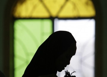 Siluet Muslimah Filipina yang sedang berdoa di Paranaque, selatan Manila, Senin.