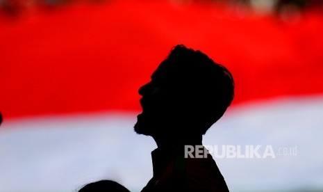 Siluet pemain Timnas Indonesia Irfan Bachdim saat menyanyikan lagu kebangsaan Indonesia Raya sebelum laga persahabatan melawan Fiji di Stadion Patriot Candrabaga, Bekasi, Sabtu (2/9).