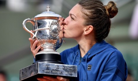 Simona Halep mencium trofi juara Grand Slam Prancis Terbuka 2018.