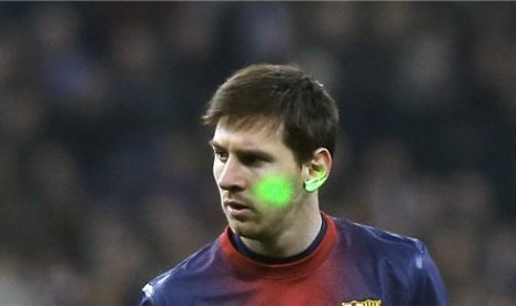 Sinar laser ditembakan ke wajah Lionel Messi, striker Barcelona, saat menghadapi Real Madrid di laga semifinal Copa del Rey di Stadion Santiago Bernabeu, Madrid, Rabu (30/1). 