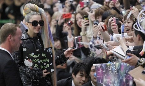 Singer Lady Gaga (with sunglasses) signs autographs for fans upon her arrival at Narita international airport in Narita, east of Tokyo, last week. 