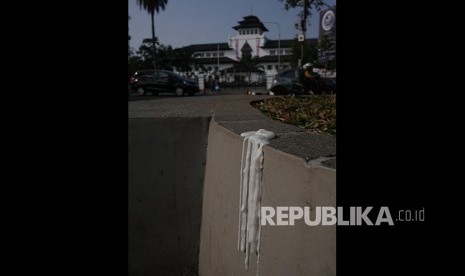 Sisa lilin yang ditinggalkan massa Aksi 1000 Lilin untuk Ahok di kawasan selatan Gasibu, Bandung, Ahad (14/5)