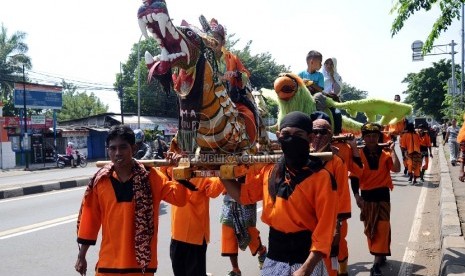 Sisingaan/odong-odong kesenian asal Subang mengarak pengaten sunat di Jl Bekasi Raya, Pulo Gebang, Jakarta Timur, Kamis (23/4). 