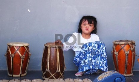 Siswa anak berkebutuhan khusus (ABK) duduk diantara alat kesenian musik tradisi.