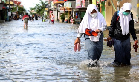 Siswa berusaha menerobos banjir yang merendam kawasan Pondok Ungu Permai, Bekasi, Jawa Barat, Kamis (25/2). 