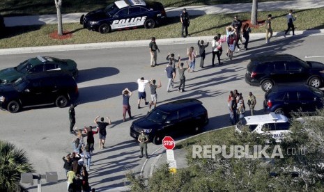 Siswa dievakuasi oleh polisi dari Marjory Stoneman Douglas High School di Parkland, Florida, pada hari Rabu (14/2), setelah seorang penembak melepaskan tembakan ke kampus.