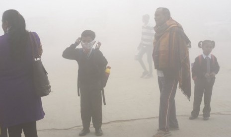 Siswa India menggunakan sapu tangan sebagai masker untuk melindungi diri dari polusi udara mematikan di New Delhi, India.