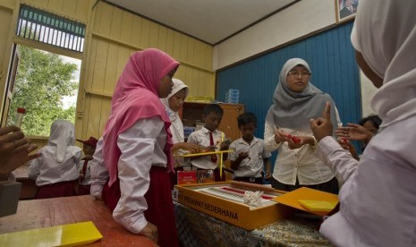  Siswa kelas 5 berdiskusi dengan guru saat praktik pelajaran fisika di SDN 14 Anggana, Desa Tani Baru, Kabupaten Kutai Kartanegara, Kalimantan Timur, Selasa (30/4).  (Antara/Yudhi Mahatma)