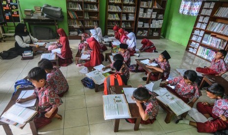 Siswa kelas dua Sekolah Dasar Negeri (SDN) Cikadongdong mengikuti Kegiatan Belajar Mengajar (KBM) di lantai ruang perpustakaan di Singaparna, Kabupaten Tasikmalaya, Jawa Barat, Rabu (17/7/2018). 