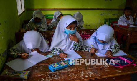 Siswa kelas I dan II mengikuti Pembelajaran Tatap Muka (PTM) terbatas dalam satu ruang kelas di Sekolah Madrasah Ibtidaiyah Pasawahan, Dusun Ciakar, Kabupaten Ciamis, Jawa Barat, Kamis (9/9/2021). Siswa terpaksa belajar di posyandu, teras warga, serta mushola lantaran belum memilik ruang kelas sejak 2017 silam, karena sekolah tersebut hanya memiliki satu ruang kelas dan ruang guru. 