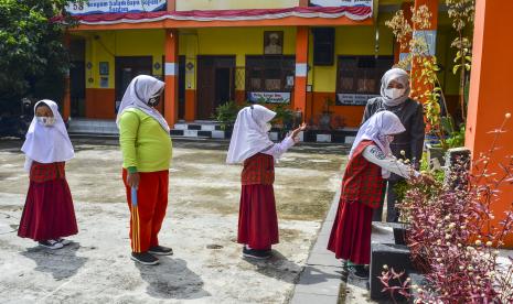 Siswa kelas III antre mencuci tangannya sebelum mengikuti Pembelajaran Tatap Muka (PTM) terbatas di SDN Dadaha, Kota Tasikmalaya, Jawa Barat, Senin (23/8/2021). Pemerintah Kota Tasikmalaya mengizinkan sekolah belajar tatap muka tingkat PAUD, SD, SMP dan SMA dengan melaksanakan protokol kesehatan COVID-19 yang ketat serta membatasi kapasitas jumlah siswa sebanyak 50 persen.