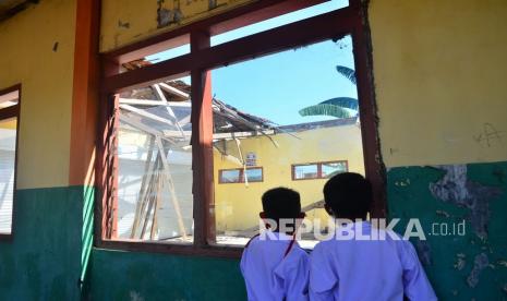 Siswa melihat ruangan kelas yang tidak beratap karena roboh di SD 4 Undaan Kidul, Kudus, Jawa Tengah, Selasa (12/10/2021). Sebanyak dua ruangan di sekolah itu yakni ruangan kelas dua dan kelas tiga atapnya roboh pada 2019 dan 2021 dan belum diperbaiki, sementara siswa belajar bergabung dengan kelas lain. 