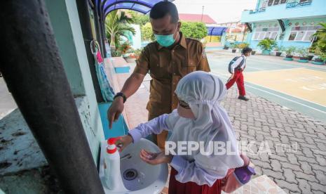 Siswa mencuci tangan sebelum memasuki ruang kelas untuk mengikuti belajar tatap muka pertama di SDN-1 Lhokseumawe, Aceh, Senin (9/11/2020). Berdasarkan surat pernyataan wali murid yang mengizinkan putra/putrinya untuk sekolah, Pemkot setempat membuka ujicoba sekolah tatap muka pertama untuk jenjang SD, SMP, SMA dengan jadwal sekolah satu kali dalam seminggu dan jumlah siswa terbatas yakni 15 siswa serta wajib mematuhi protokol Kesehatan. 