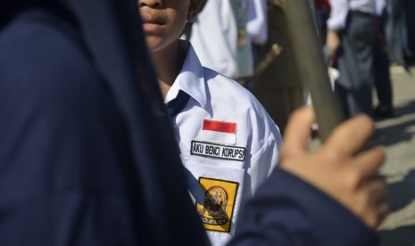 Siswa mengenakan atribut 'Aku Benci Korupsi' saat mengikuti Masa Orientasi Siswa (MOS) Bersama di Lapangan Karebosi, Makassar, Sulawesi Selatan, Selasa, (28/7).